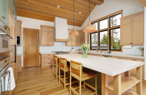 Coeur d'Alene House | A 5,200 sq ft home on the Spokane River, twelve minutes to Coeur d'Alene and ten to downtown Post Falls. Six bedrooms and five full baths across the main house and guest house, plus a private sandy beach, a dock, and a river-view hot tub.