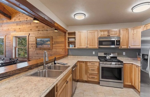 Clark Cabin | Comfortable private queen room in the True North Adventure Lodge. Includes a queen bed, private ensuite bathroom, and access to shared amenities like the kitchen, great room, and hot tub. Great for couples or solo travelers.